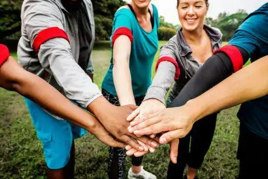 People placing their hands together outdoors