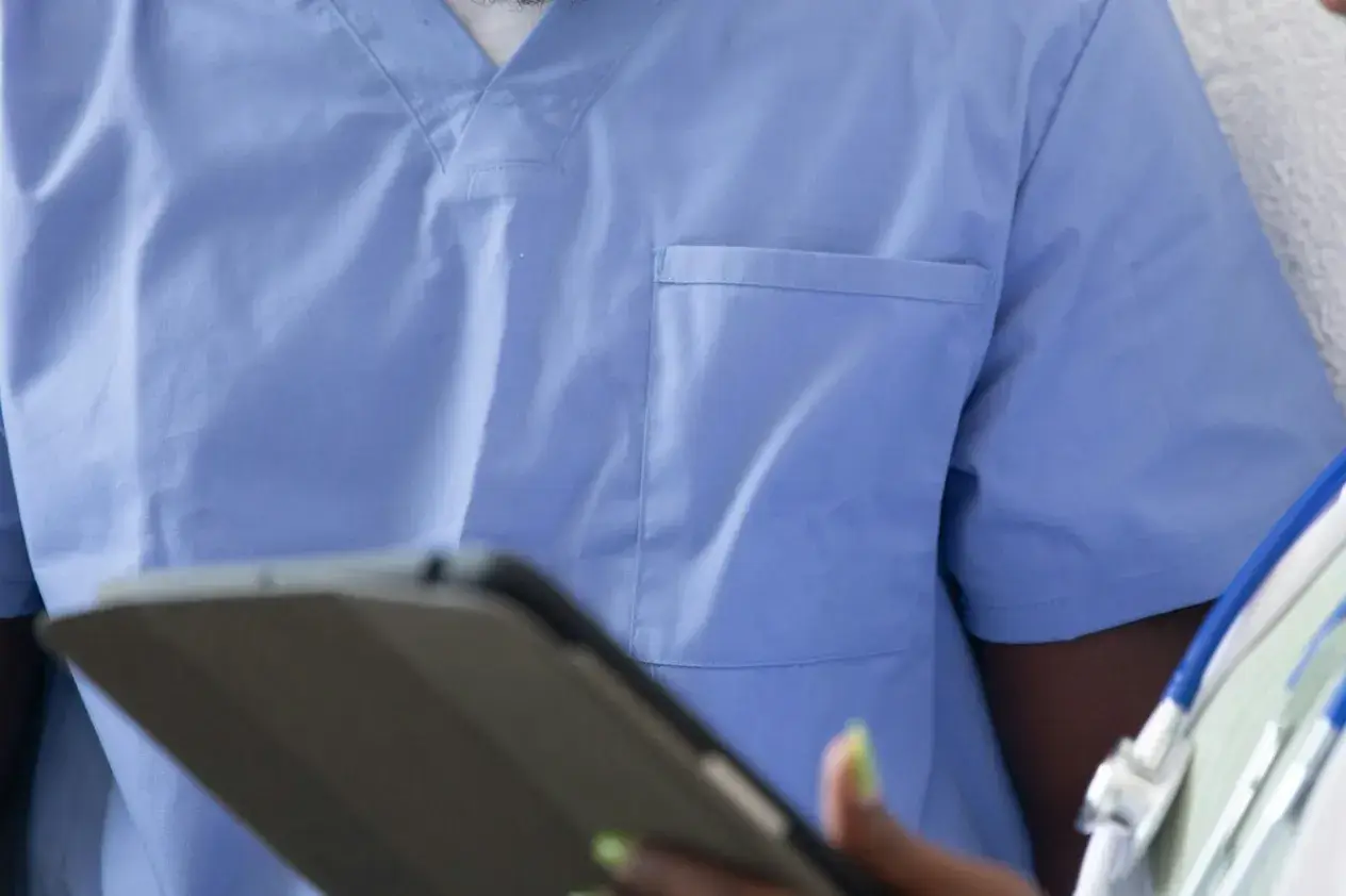 Close-up of a person wearing blue medical clothing